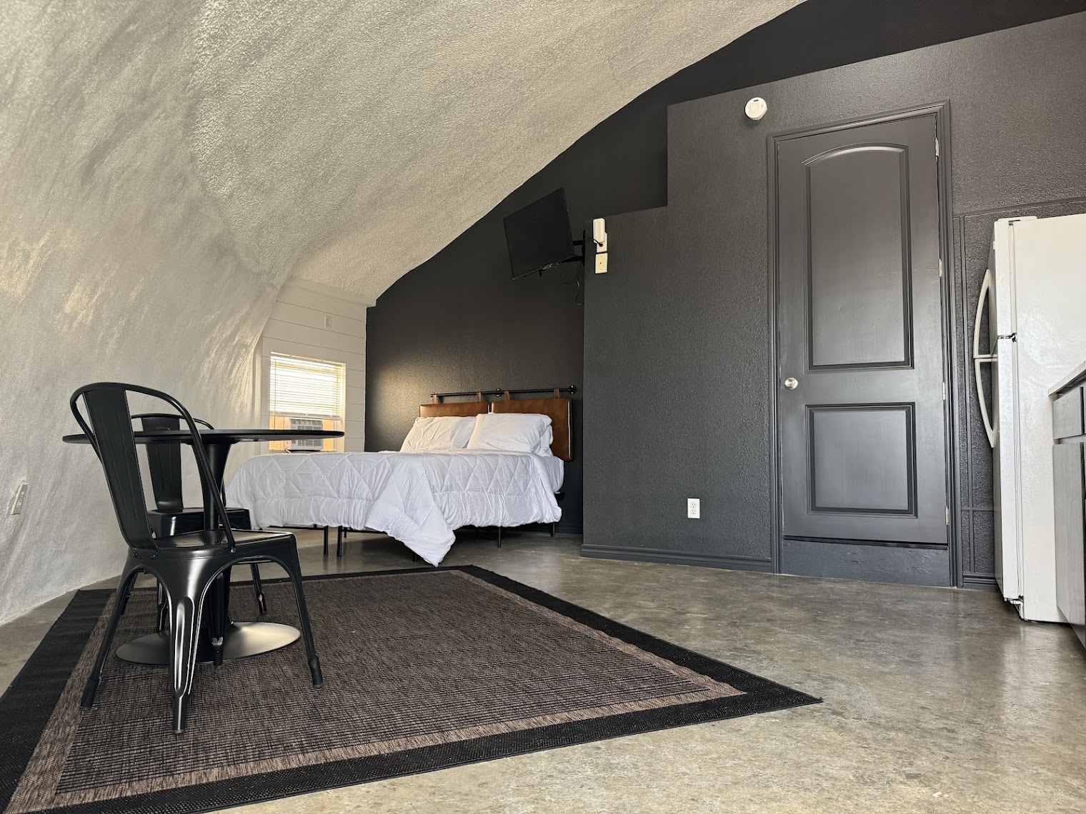 Queen bed and seating area inside a dome room at The Domain, Aransas Pass