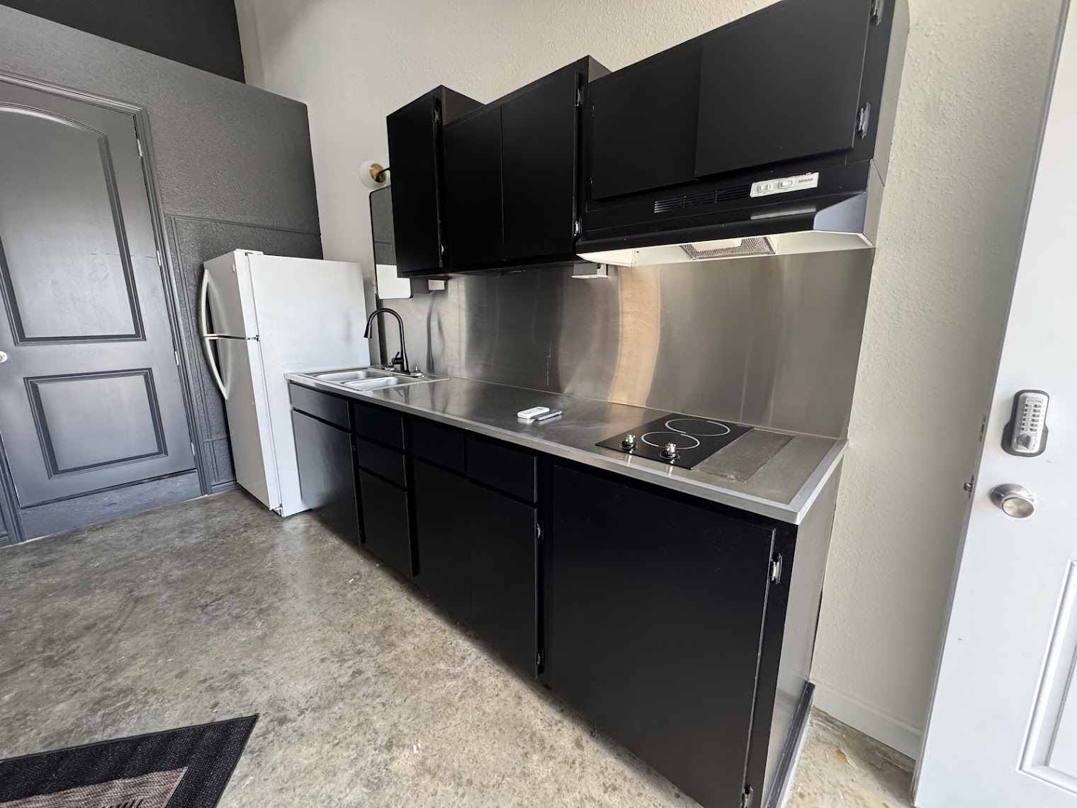 Kitchenette with stainless counter, cooktop and refrigerator in a dome at The Domain