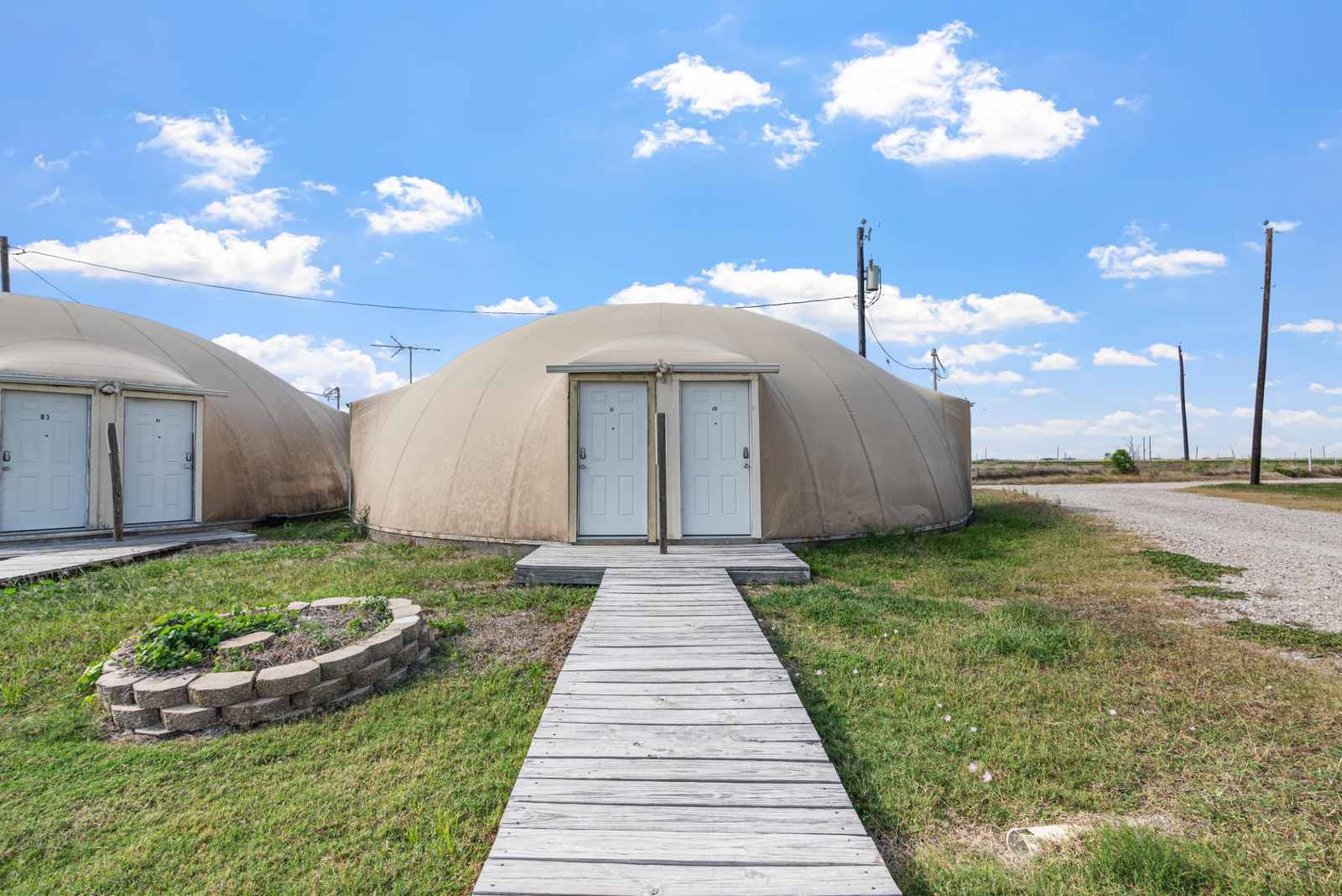Dome units and boardwalk entrance at The Domain Hotel RV Park & Storage